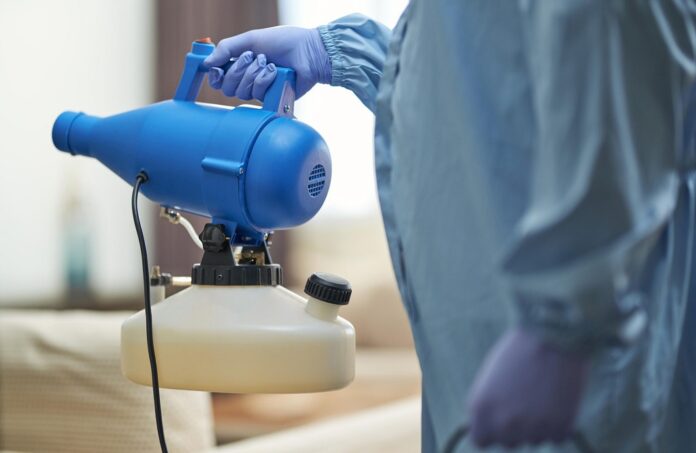 worker-in-protective-suit-holding-disinfectant-and-2025-03-26-12-15-22-utc-scaled